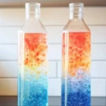 A colorful DIY lava lamp with vibrant wax blobs rising and falling in a glass bottle.
