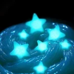 A jar of vibrant glow in the dark slime shining brightly in a dark room.