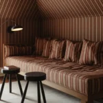Living room showcasing pattern drenching design with patterned wallpaper and textiles.