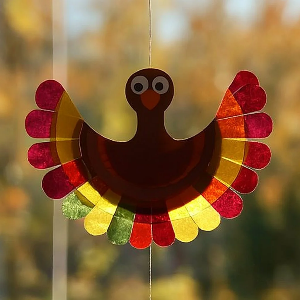Colorful paper plate turkey suncatcher craft for Thanksgiving decorations