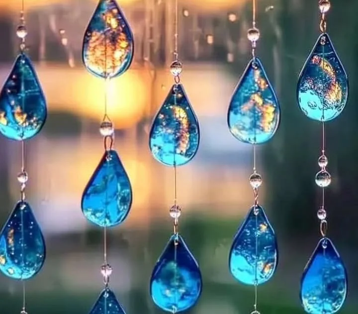 Colorful blue crayon suncatchers hanging in a window, creating beautiful light reflections