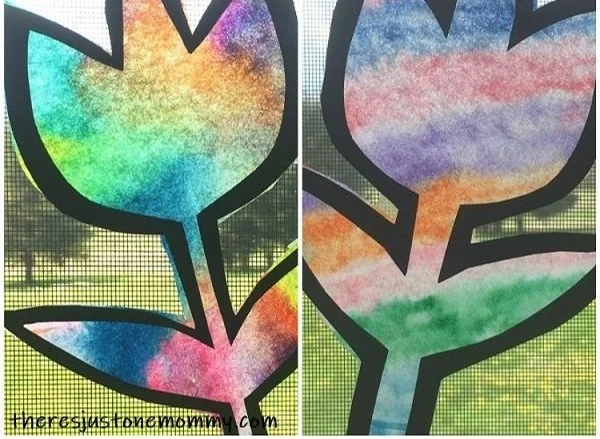 Colorful coffee filter suncatcher hanging by the window in spring sunlight
