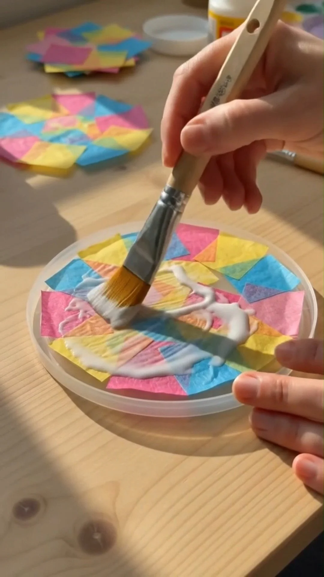 Mod Podge tissue paper suncatchers glow beautifully in sunlight with colorful stained-glass effects. A fun and creative DIY kids love. Save this project!